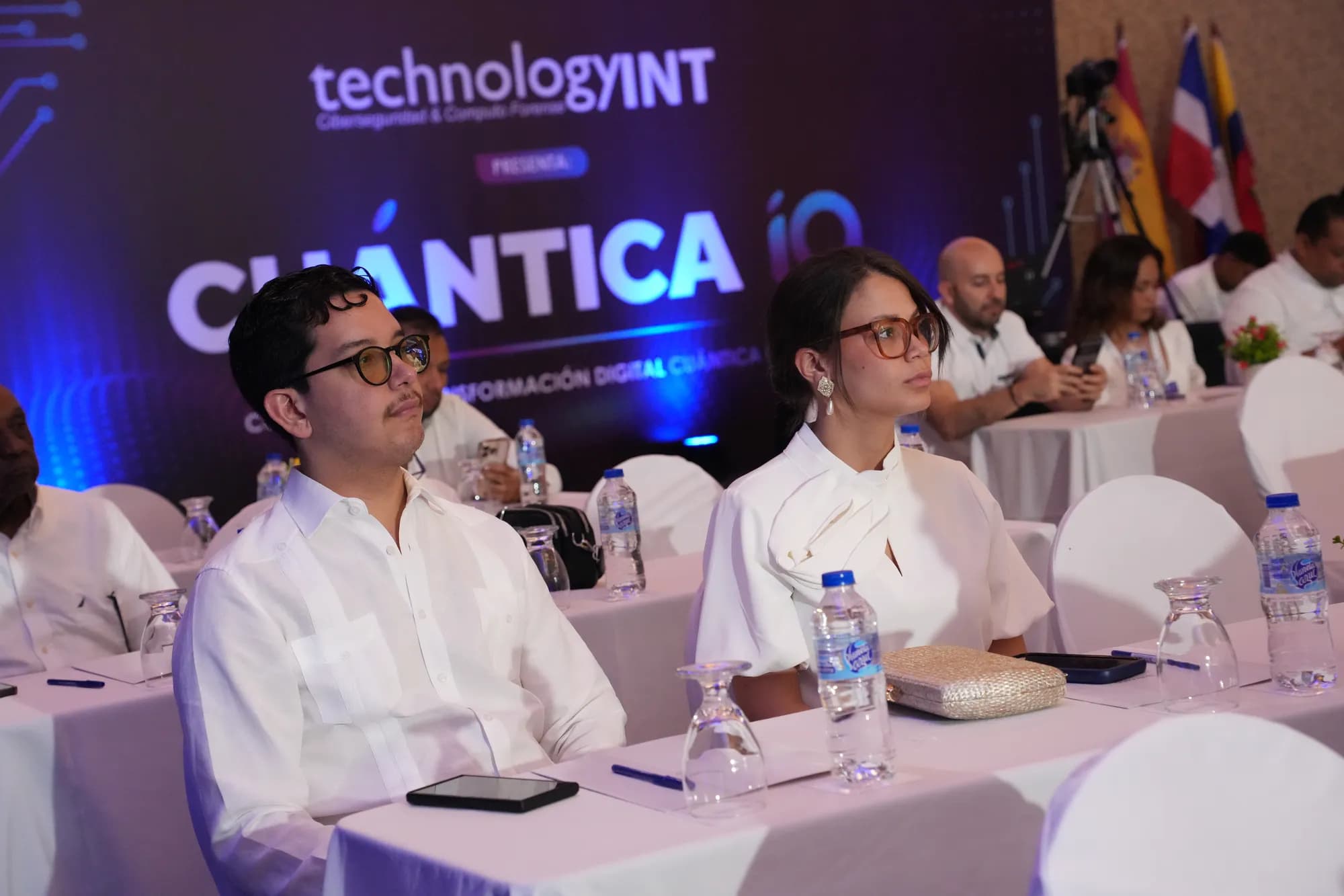 Lucas Pradel and a fellow attendee seated in the audience at CuánticaIA 2026, with the illuminated congress screen behind them.